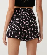 Short runner negro con estampado de lombrices rosas y cuadrillé blanco, de cintura media con elástico.