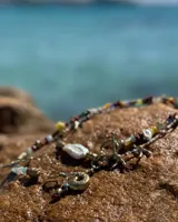 Collar corto con cuentas de piedra natural multicolor, perlas de río irregulares y dijes de bronce con forma de coral.