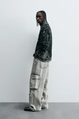Sweater negro con cuello redondo y manga larga, tejido con diseño geométrico jacquard en blanco.