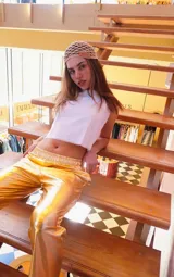 Pantalón dorado de calce relajado, cintura elástica, bolsillos delanteros y traseros, de textura suave y liviana.