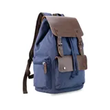 Mochila negra de tela canvas con detalles en símil cuero marrón, cierre superior marinero, bolsillos internos y externos con cierre metálico, asas rígidas y correas ajustables.
