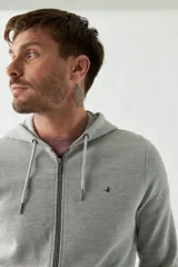 Campera gris de felpa con capucha, cierre frontal, bolsillos laterales con cierre, puños elásticos y logo bordado en el pecho.