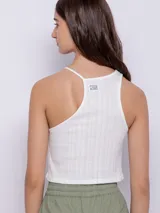 Top corto sin mangas, asimétrico y de tela texturada, ideal para combinar en diversas ocasiones.