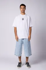 Remera oversize blanca de algodón con un pequeño estampado circular en el pecho que simula un cerebro o un diseño abstracto en espiral, en color negro.