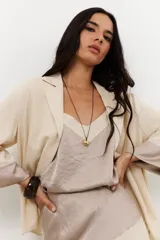 Colgante con cadena fina negra y dije dorado con forma irregular.