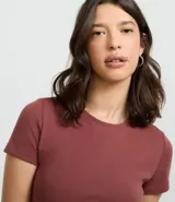 Vestido corto color ladrillo, confeccionado en tejido de punto rib de algodón y elastano. Tiene cuello redondo y mangas cortas.