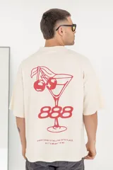 Remera color crema de corte holgado con estampado en la espalda de una copa de cóctel con cerezas y el número 888 en color rojo.
