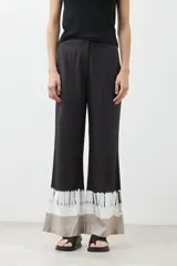 Pantalón de vestir negro con efecto tie dye en gris y blanco en el ruedo, corte palazzo.