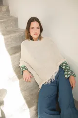 Poncho tejido en hilo de algodón con lurex color negro y dorado, con flecos en el ruedo.