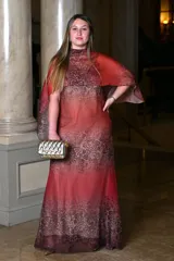 Vestido largo de gasa con estampado animal print en tonos rojizos y marrones, cuello alto y capa corta sobre los hombros.