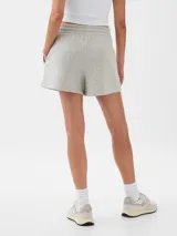 Short deportivo de felpa color crema con estampado floral multicolor y logo GAP bordado en rojo.