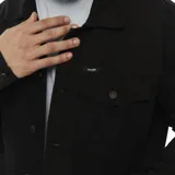 Campera Wrangler de denim color negro, con cuello clásico, cierre frontal con botones metálicos, bolsillos de parche con solapa abotonada en el pecho y bolsillos laterales.