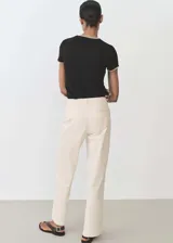 Camiseta a rayas horizontales blancas y negras, de manga corta y cuello redondo con ribetes negros.