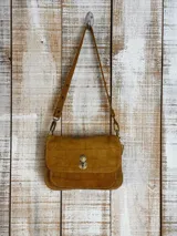 Minibag tipo acordeón, color negro con acabado brillante o glitter. Presenta solapa frontal con cierre metálico dorado de giro. Incluye correa larga ajustable y correa corta de mano.