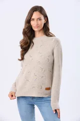 Buzo tejido de abrigo color beige, con cuello redondo y mangas largas. Presenta un delicado diseño bordado en el frente con pequeños motivos en tonos pastel.