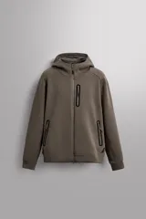 Sudadera con capucha color marrón topo, de corte regular fit, confeccionada en tejido técnico compacto de algodón con elasticidad. Cuenta con cuello subido, manga larga con bolsillo, bolsillos frontales con cierre de cremallera y acabados con rib del mismo tejido.