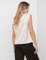 Blusa de gasa color beige con textura labrada, sin mangas, con hombreras internas y abertura en la espalda con botón.