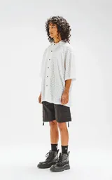 Camisa blanca con estampado de abanicos en tonos celeste, azul y amarillo.