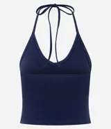 Blusa cropped de frente única color crema, confeccionada en algodón con elastano, con escote en V y lazo en el cuello.