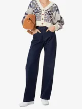 Pantalón de jean azul oscuro de corte ancho, con cintura alta, pretina con trabillas, cinco bolsillos y cierre frontal con botón y cremallera.