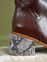 Botas de cuero color marrón, de caña media y taco geométrico con estampado animal print. Cierre lateral con cremallera.