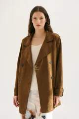 Trench simil gamuza color marrón, con cuello de solapa muesca, cuatro botones delanteros, bolsillos laterales y cinturón a la altura de la cintura.