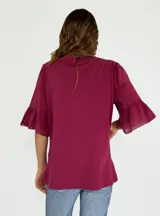 Blusa azul marino de corte recto, cuello redondo y mangas cortas con volados.