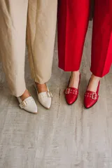 Zapato de cuero rojo con taco cuadrado y detalle de hebilla dorada.
