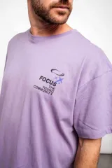 Remera violeta de corte holgado con estampado en el pecho que dice "Focus The Young Community".