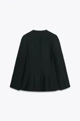 Blazer negra entallada, de escote pico y manga larga con hombreras. Tiene bolsillos delanteros de vivo y cierre frontal con botones a presión ocultos.