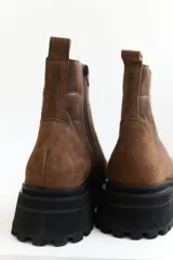 Botas de cuero negro con punta cuadrada, caña media y cierre lateral con cremallera.