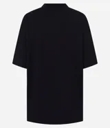 Remera negra de algodón con cuello redondo y mangas cortas. Presenta un estampado frontal de estilo gótico con la palabra "DISRUPTION" y un castillo sombrío.