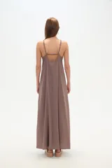 Vestido largo color marrón topo, de corte holgado, con escote en V y tirantes finos ajustables con argollas metálicas.