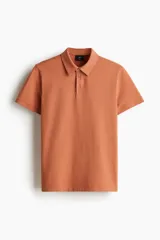 Remera polo color ladrillo de punto de algodón liviano, corte slim fit, manga corta, cuello clásico con tapeta de botones y bajo recto.
