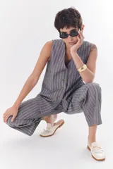 Pantalón de lino a rayas verticales azules y beige, de corte recto y relajado.