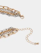 Set de cuatro collares cortos con cadenas de eslabones de metal plateado y dorado, con cierre de mosquetón y cadena de alargue.