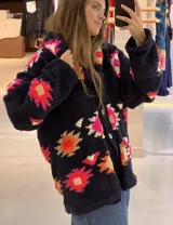 Saco de lana marrón con diseño geométrico multicolor, cuello con solapa, cierre frontal con botones y bolsillos delanteros.