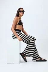 Pantalón tejido con motivo zigzag en tonos beige y blanco, de corte flare y cintura elastizada.