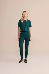 Calza larga de lycra color verde oscuro, de alta compresión, con bolsillos laterales.