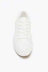 Zapato deportivo tipo blucher color blanco con suela marrón.
