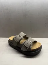 Sandalias marrones con dos tiras anchas y hebillas plateadas.