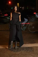 Vestido midi negro de punto elástico con escote asimétrico, manga corta con detalle girado, frunces en un hombro y en un lateral para crear un leve efecto drapeado.
