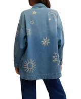 Chaqueta de algodón con bordados de sol, estrella y luna. Tiene cuello monocolor, bolsillos en el pecho y en el bajo, cierre de botones completo y hombros caídos.