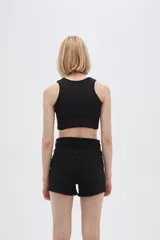 Top negro de bretel ancho, confeccionado en poliamida con textura acanalada. Diseño al cuerpo con escote profundo en forma de U.
