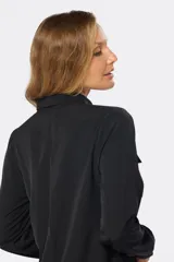 Blusa tipo camisa blanca con estampado de pequeñas flores negras, manga larga, botones nacarados ocultos con cartera y doble capa en el frente para evitar transparencias.