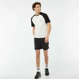 Camiseta blanca con mangas cortas raglán negras y logo pequeño en el pecho.