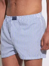 Bóxer de algodón blanco con estampado de flores pequeñas color celeste, con cintura elástica y logo de la marca en el centro.