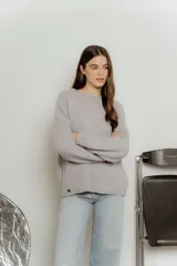Sweater de punto color gris claro, de corte holgado y mangas largas.