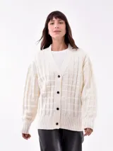 Saco color off white con diseño de punto y corte relajado, botones frontales.