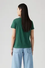 Remera verde con estampado circular con el logo de Levi's y un paisaje montañoso.